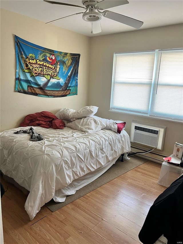 bedroom with a wall mounted AC, ceiling fan, and light hardwood / wood-style flooring