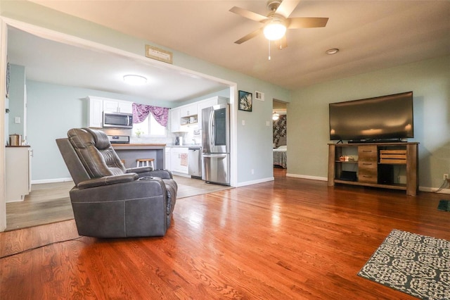 living room featuring ceiling fan and wood-type flooring