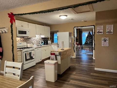 kitchen with backsplash, white cabinets, dark hardwood / wood-style floors, and white appliances