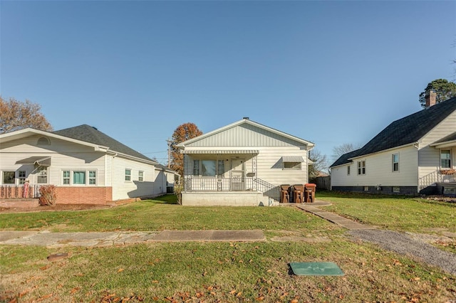 rear view of property featuring a lawn