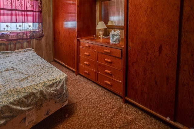 bedroom with carpet floors and wooden walls