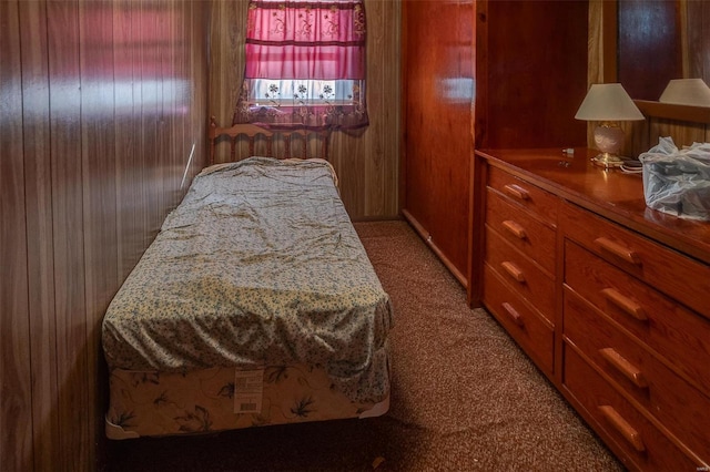 bedroom featuring carpet flooring and wooden walls