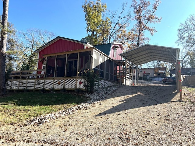 rear view of house featuring a carport and a sunroom