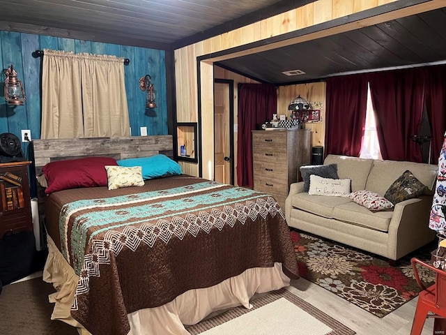 bedroom with wooden walls, hardwood / wood-style floors, and wooden ceiling