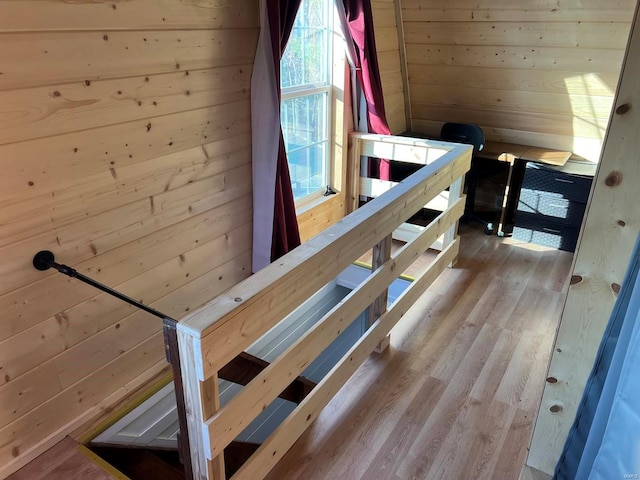 staircase with hardwood / wood-style flooring and wood walls