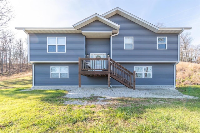 back of house featuring a lawn and a wooden deck