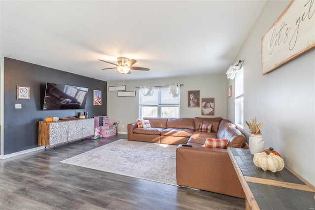 living room with ceiling fan and dark wood-type flooring