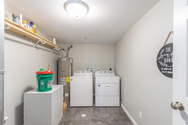 laundry area featuring washing machine and dryer, a textured ceiling, and water heater