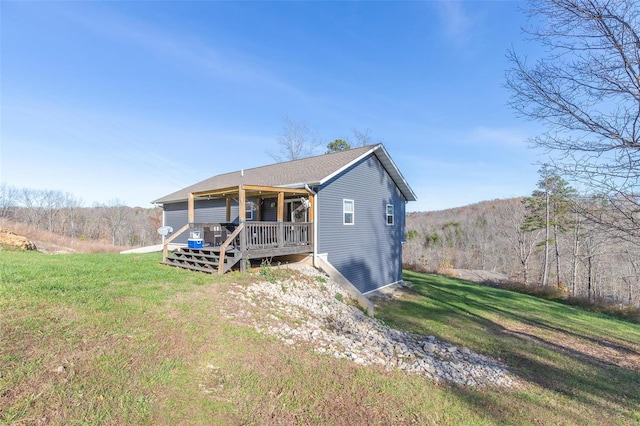 view of front of property with a front yard and a deck