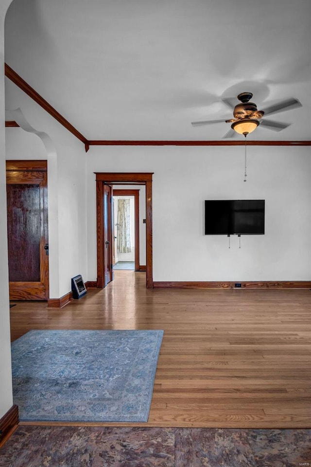 unfurnished living room featuring hardwood / wood-style flooring, ceiling fan, and crown molding