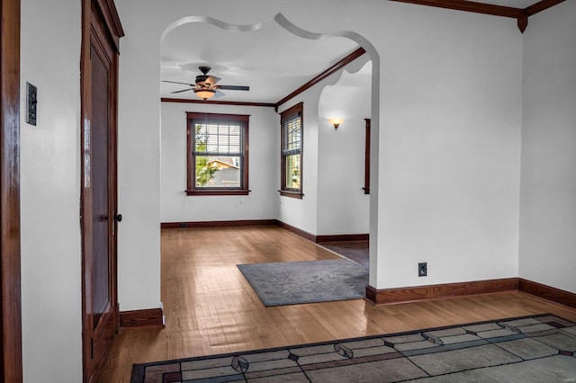 empty room featuring hardwood / wood-style flooring, ceiling fan, and crown molding