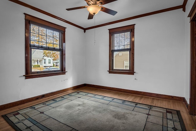 spare room featuring hardwood / wood-style flooring, a wealth of natural light, crown molding, and ceiling fan