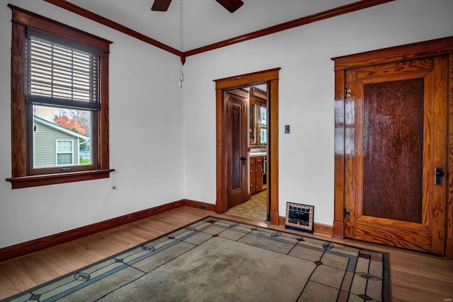 empty room with crown molding, ceiling fan, and light wood-type flooring