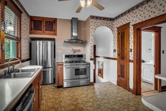 kitchen featuring appliances with stainless steel finishes, ceiling fan, wall chimney exhaust hood, and sink