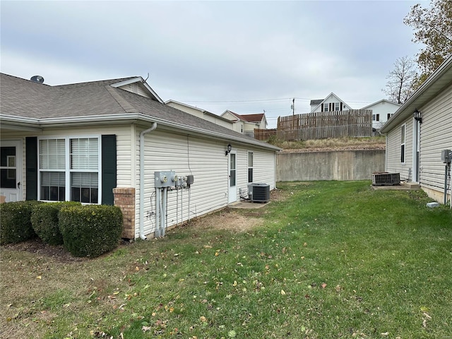 view of side of property featuring a yard and central AC unit