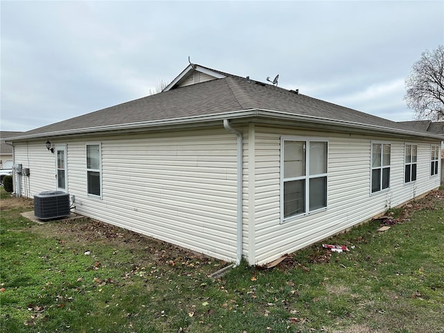 view of property exterior featuring a lawn and central air condition unit