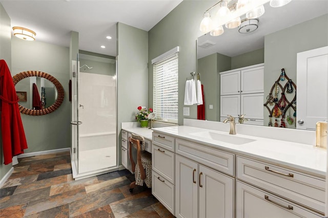 full bath featuring recessed lighting, stone finish flooring, a shower stall, vanity, and baseboards