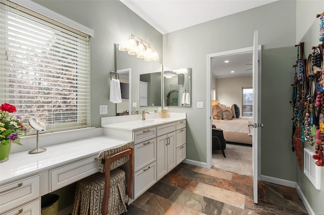 bathroom featuring baseboards, ensuite bathroom, stone finish flooring, vanity, and recessed lighting