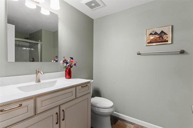 bathroom with a stall shower, baseboards, visible vents, toilet, and vanity