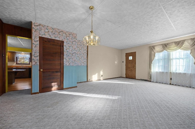 carpeted empty room featuring wooden walls