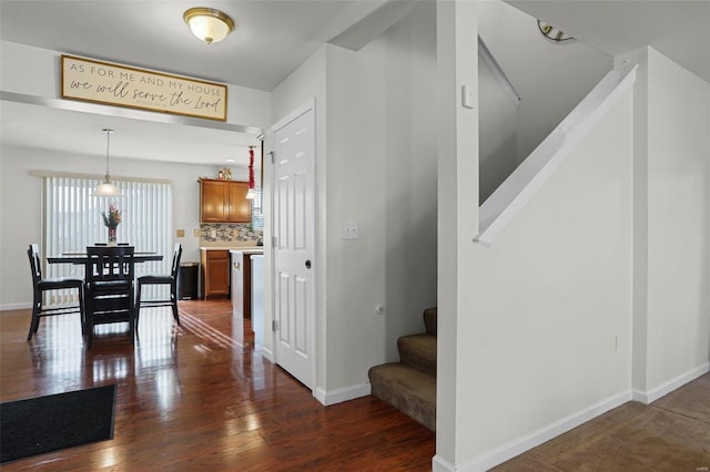 stairway with hardwood / wood-style floors and a notable chandelier