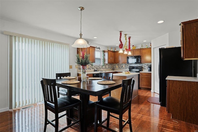 dining area with dark hardwood / wood-style floors and sink