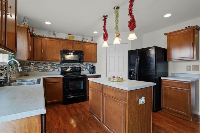 kitchen featuring a center island, black appliances, sink, decorative light fixtures, and dark hardwood / wood-style flooring