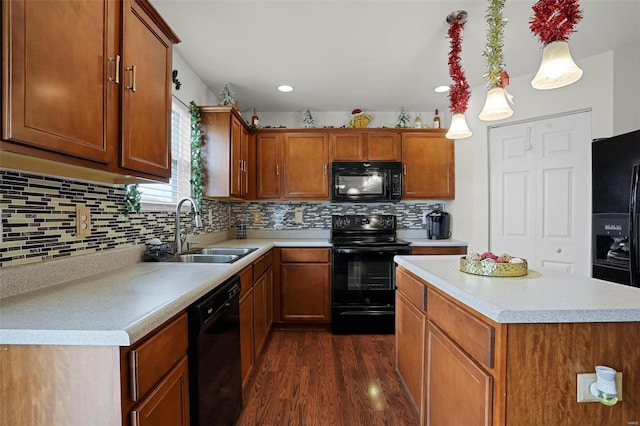 kitchen with sink, dark hardwood / wood-style floors, pendant lighting, decorative backsplash, and black appliances