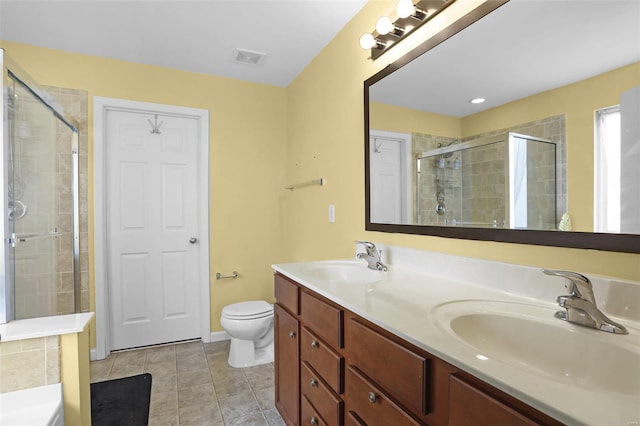 bathroom with vanity, a shower with door, tile patterned flooring, and toilet