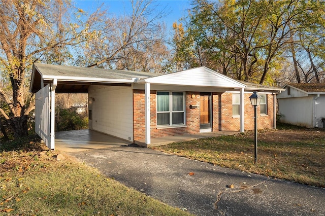 ranch-style home featuring a front lawn and a carport