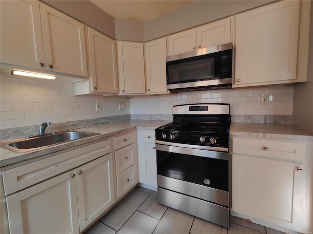 kitchen with white cabinets, appliances with stainless steel finishes, and tasteful backsplash