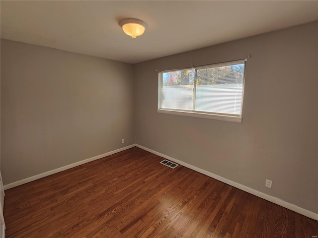 unfurnished room with dark wood-type flooring