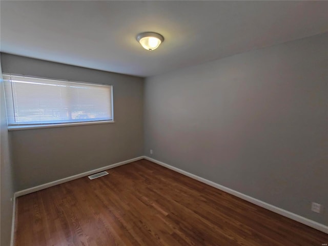 spare room with dark hardwood / wood-style floors