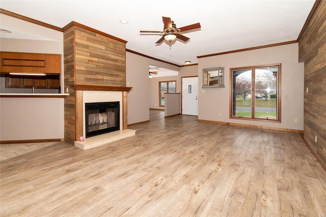 unfurnished living room with a tile fireplace, ceiling fan, light hardwood / wood-style floors, and ornamental molding