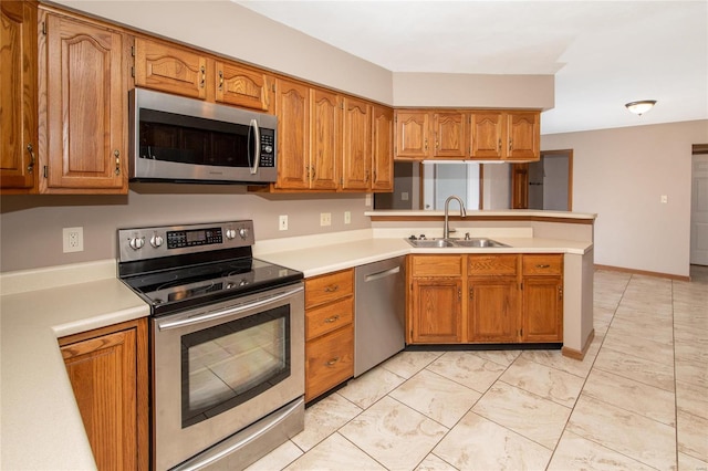 kitchen with kitchen peninsula, stainless steel appliances, and sink