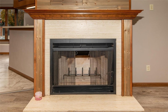 details with a tile fireplace and wood-type flooring