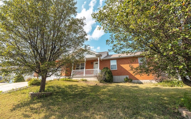 ranch-style house featuring covered porch and a front yard