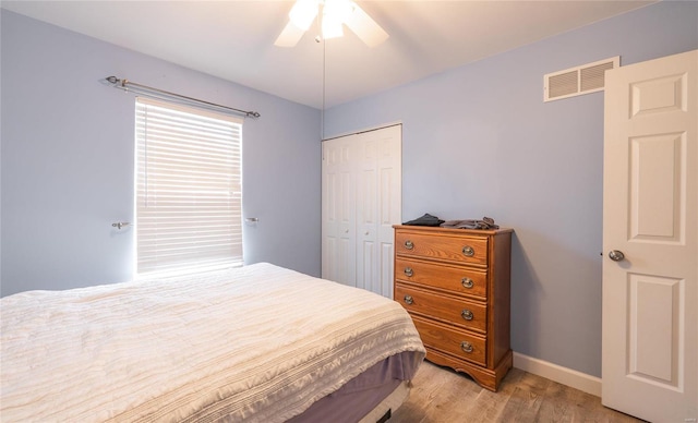 bedroom with a closet, light hardwood / wood-style flooring, and ceiling fan