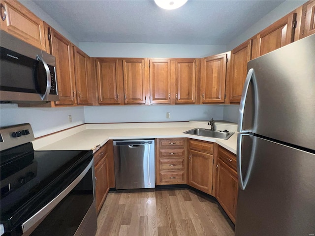 kitchen featuring sink, stainless steel appliances, and light hardwood / wood-style flooring