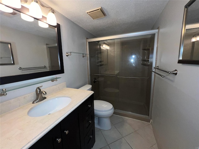 bathroom featuring vanity, tile patterned flooring, toilet, a textured ceiling, and walk in shower