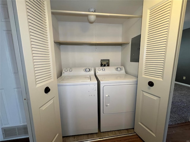 laundry room featuring electric panel, separate washer and dryer, and dark wood-type flooring