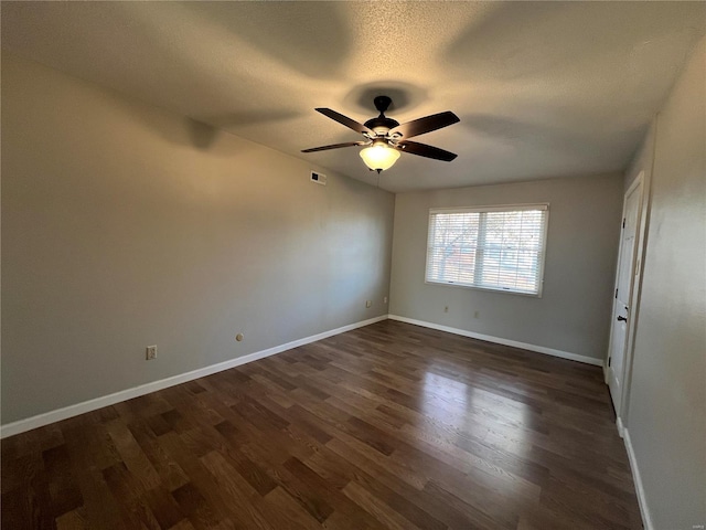 spare room featuring dark hardwood / wood-style floors, ceiling fan, and a textured ceiling