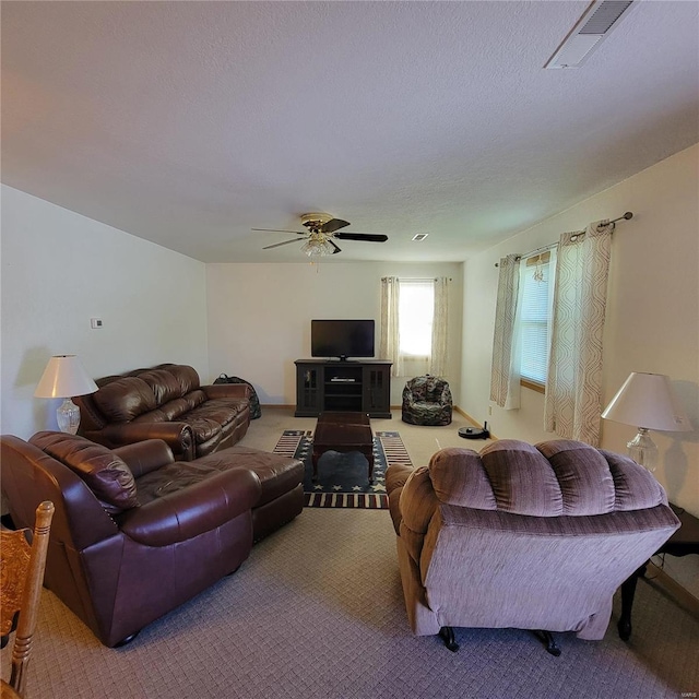 living room with carpet, ceiling fan, and a textured ceiling