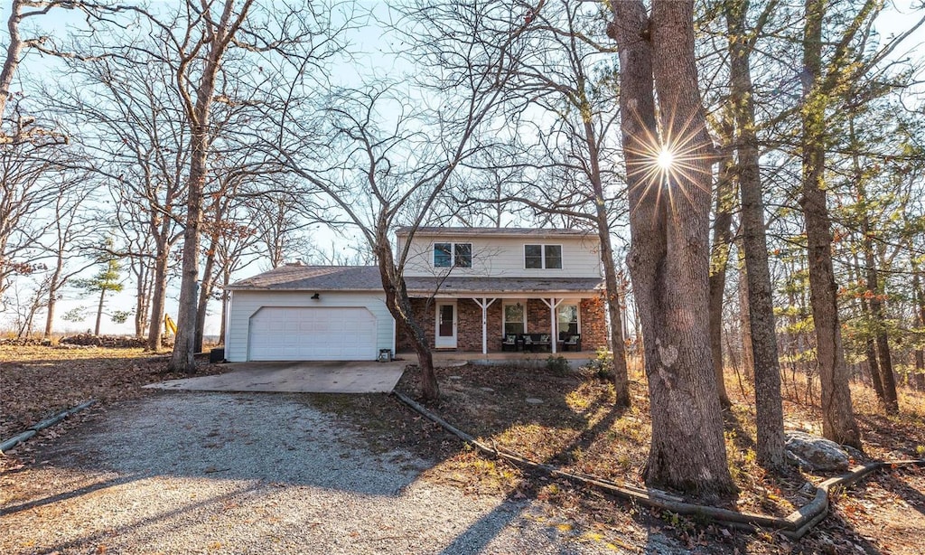 front facade featuring covered porch and a garage