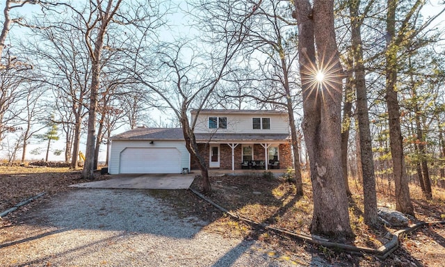 front facade featuring covered porch and a garage