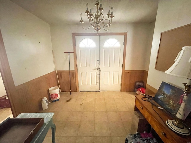 entryway featuring a notable chandelier and wood walls