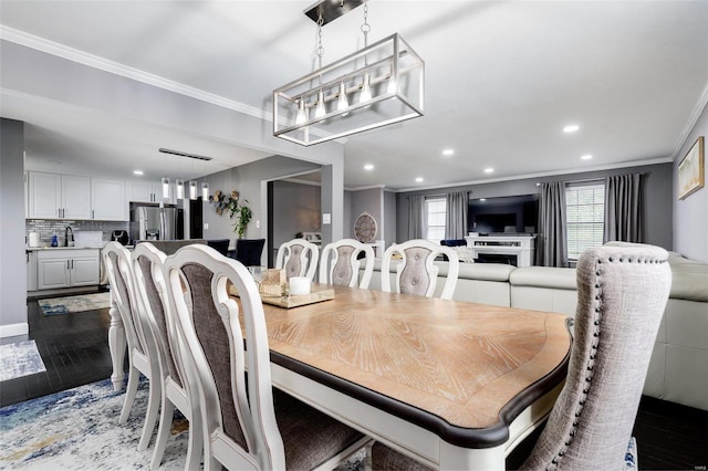 dining space with dark hardwood / wood-style floors, ornamental molding, and sink