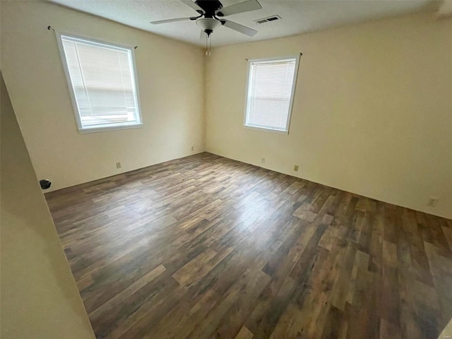 empty room featuring ceiling fan and dark wood-type flooring