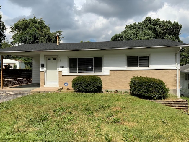 single story home featuring a front yard and a carport