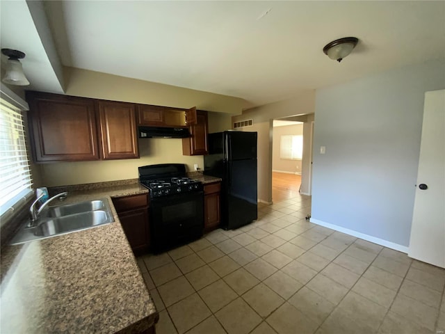 kitchen featuring sink, light tile patterned floors, and black appliances